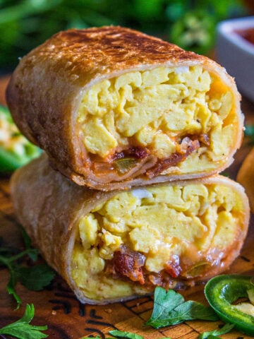 Morning Burritos with eggs, bacon, cheesy, and salsa cut in half and stacked.