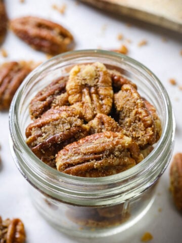 Vertical view of Candied Pecans in a mason jar.