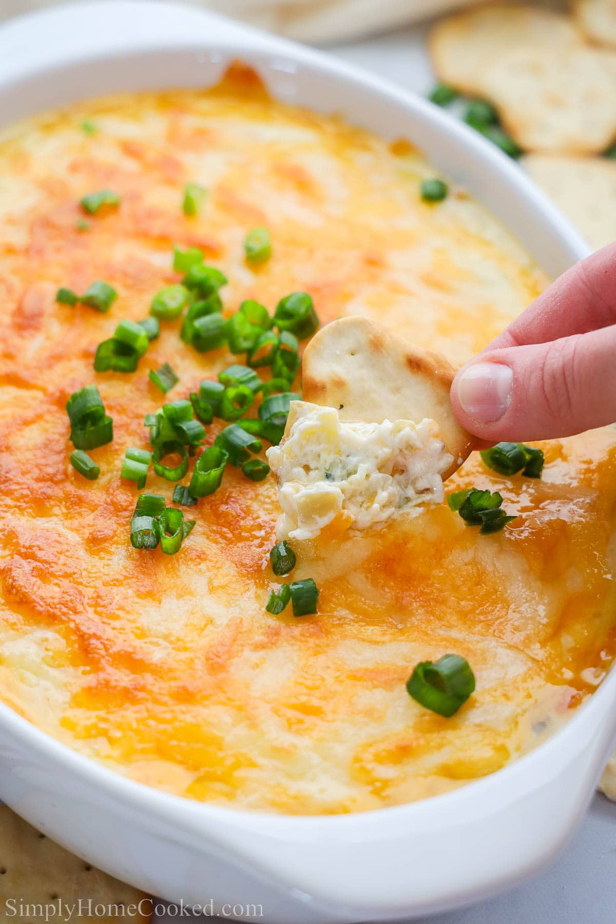 Cette délicieuse trempette maison au crabe et aux épinards et artichauts est l'apéritif parfait et se marie très bien avec presque n'importe quoi. Fromage et savoureux, avec des morceaux de crabe et d'artichaut mélangés, cela fera revenir tout le monde pour en avoir plus. #meilleuretrempetteauxcrabesetartichauts #recetteauxépinardsaveccrevettesauxcarabes #apéritifmaisonauxcrabesetartichauts #meilleurcrabeendéco Trempette au crabe et aux artichauts garnie d'oignons verts et une chips qui trempe dedans.