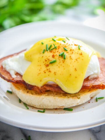 Oeufs Bénédicte sur un muffin anglais avec du bacon canadien et un œuf poché et de la sauce hollandaise.