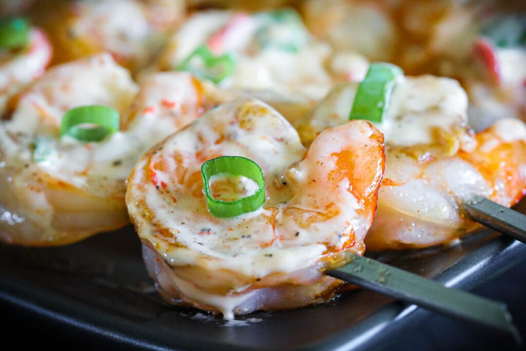 Bonefish Grill copycat Bang Bang shrimp with a healthier barbecued twist. It's creamy, sweet, spicy, and slightly smoky from the grill, DELICIOUS! #bangbangshrimp #bonefishgrillcopycat #firecrackershrimp #grilledshrimp #easyshrimp Barbecued Bang Bang Shrimp on sticks.