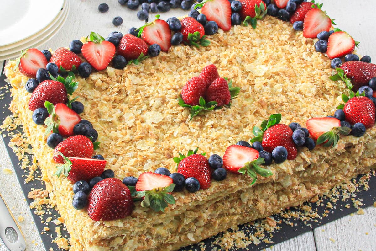 Crispy puff pastry layered with velvety, sweet cream, this Napoleon dessert is effortless to prepare and a beloved family choice. #homemadenapoleoncake #homemaderussiandessert #easynapoleondessert #napoleondessertrecipe Simple Napoleon Cake garnished with ripe berries.