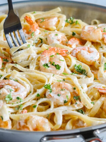 Vertical image of Shrimp Alfredo Pasta in a pan with a fork