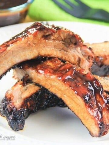 barbecue pork ribs stacked on each other on a plate