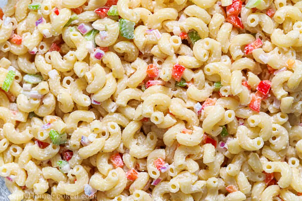 For an easy to prepare side dish, try this Classic Luscious Pasta Salad. It's velvety and full of flavor, with crunchy finely cut vegetables to give it amazing texture. #lusciouspastasaladrecipe #finestlusciouspastasalad #homemadepastasaladrecipe #bestclassiclusciouspastasaladrecipe Close up of Classic Luscious Pasta Salad with finely cut vegetables and elbow macaroni.