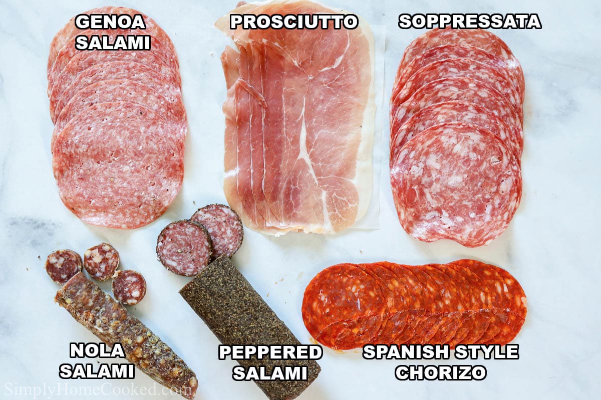 If you are having people over, you have to try this Ultimate Deli Board recipe. You'll be able to serve the most beautiful and delicious appetizer your guests have ever seen! #bestcharcuterieboard #bestcheeseboard #bestcheeseplatter #bestmeatsforcharcuterieboard Meats for an Ultimate Deli Board: genoa salami, prosciutto, soppressata, Spanish style chorizo, peppered salami, and nola salami.