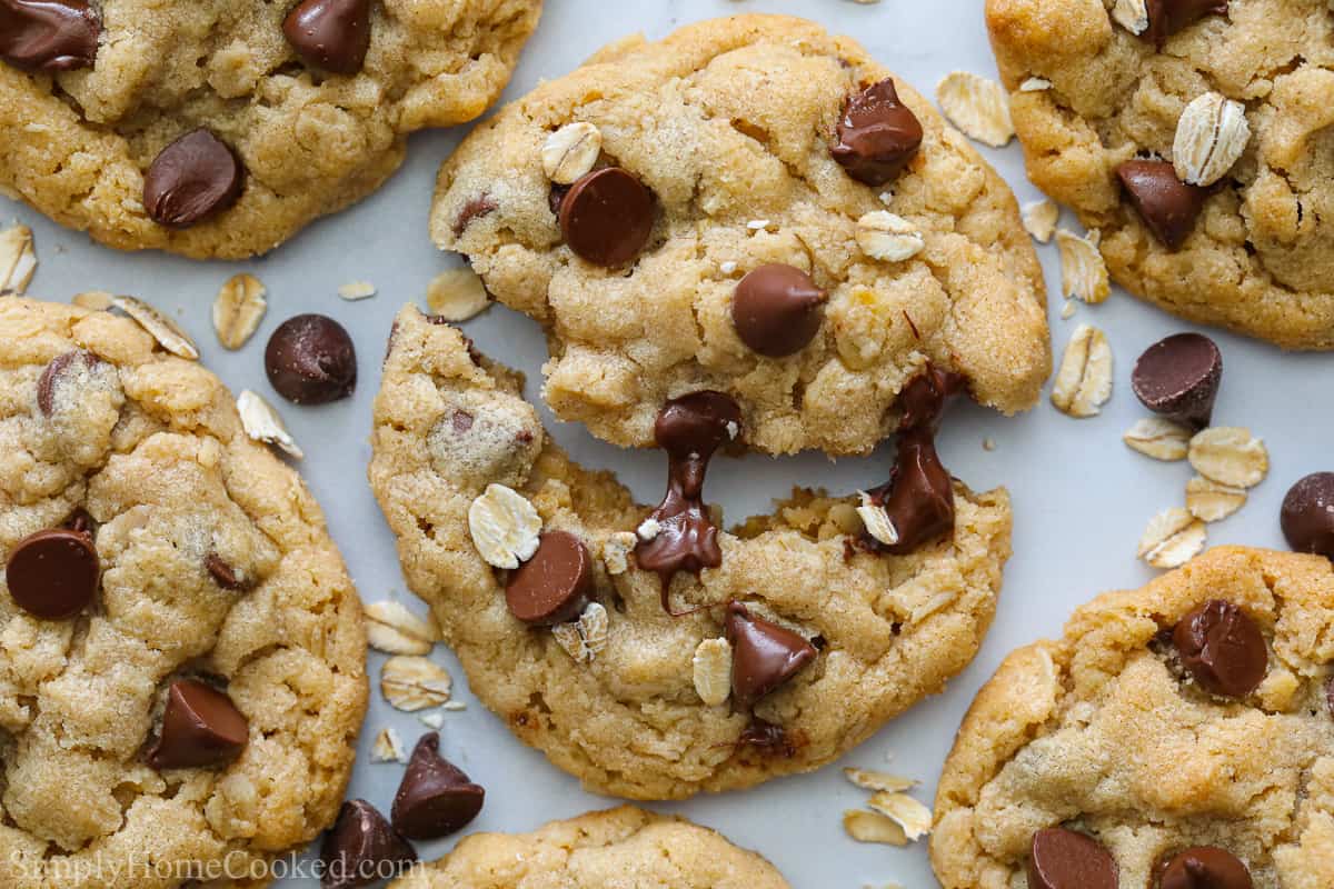 These Chewy Peanut Butter Oatmeal Cookies are so amazing, you're going to want to make a double batch! Soft and sweet with gooey chocolate chips, they are sinfully scrumptious. #peanutbutteroatmealcookies #chewyoatmealcookies #chewypeanutbuttercookies #chewychocolatechipcookies Chewy Peanut Butter Oatmeal Cookies with gooey chocolate chips, one cookie pulled apart.